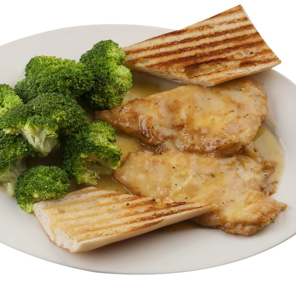 Chicken cutlets in a creamy sauce with steamed broccoli and grilled bread on a white plate.