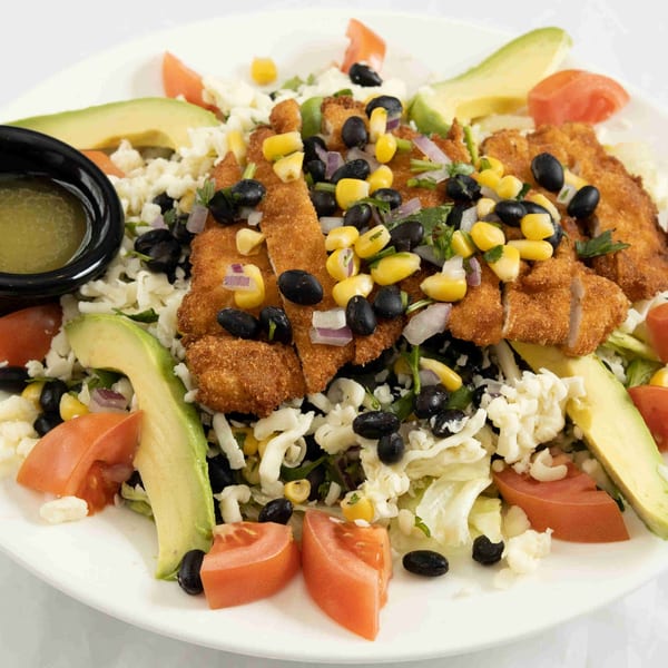 A vibrant Town Pub salad with crispy chicken, avocado, corn, black beans, tomatoes, and cheese.