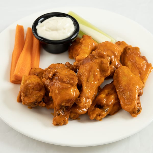 Town Pub's buffalo wings with carrots, celery, and ranch dressing on a white plate.