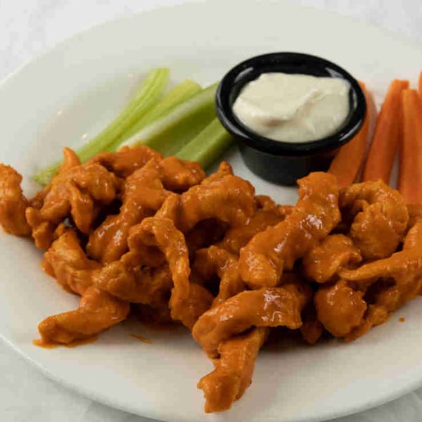 Town Pub's boneless buffalo chicken wings with celery, carrots, and ranch dressing on a white plate.