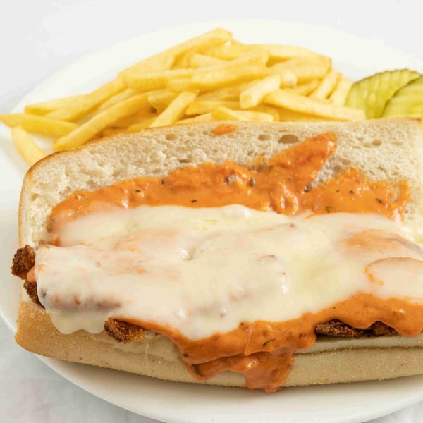 Chicken parmesan sub with melted cheese and red sauce, served with fries and a pickle.